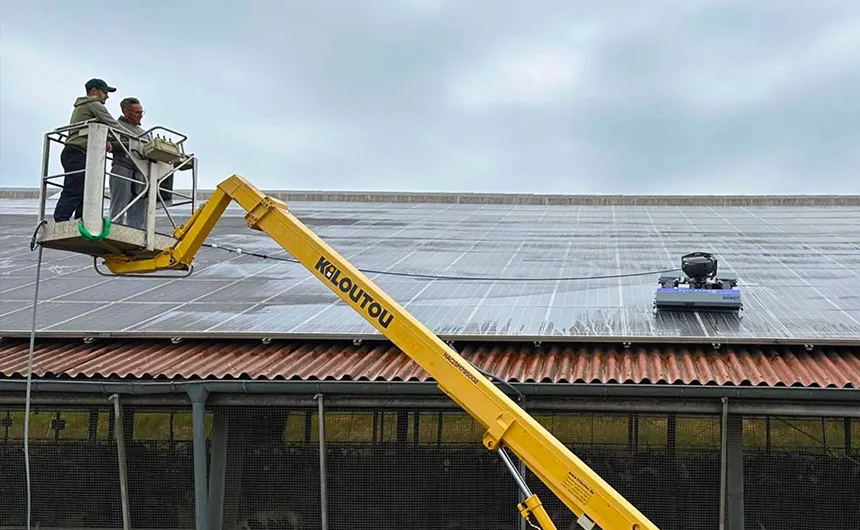 Zwei Personen auf einer Hebebühne kontrollieren die Arbeit eines solarROBOT pro