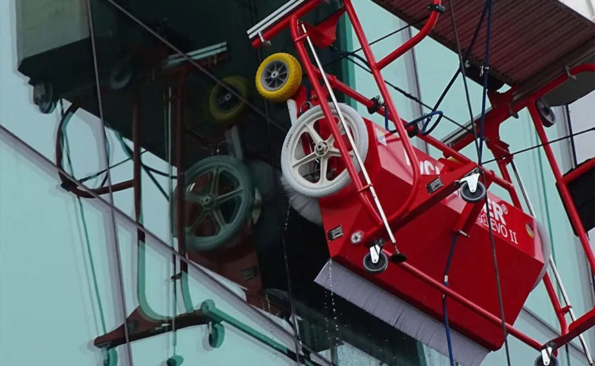 Le robot de nettoyage facadeBRUSH v-line est positionné sur une façade en verre