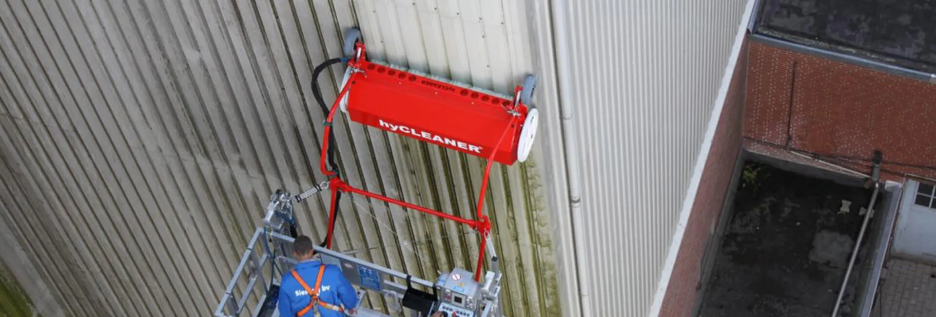 Le robot de nettoyage facadeBRUSH v-line nettoie une façade en tôle