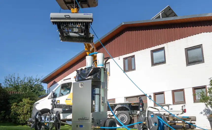 The cleaning robot solarROBOT pro is lifted onto a house roof